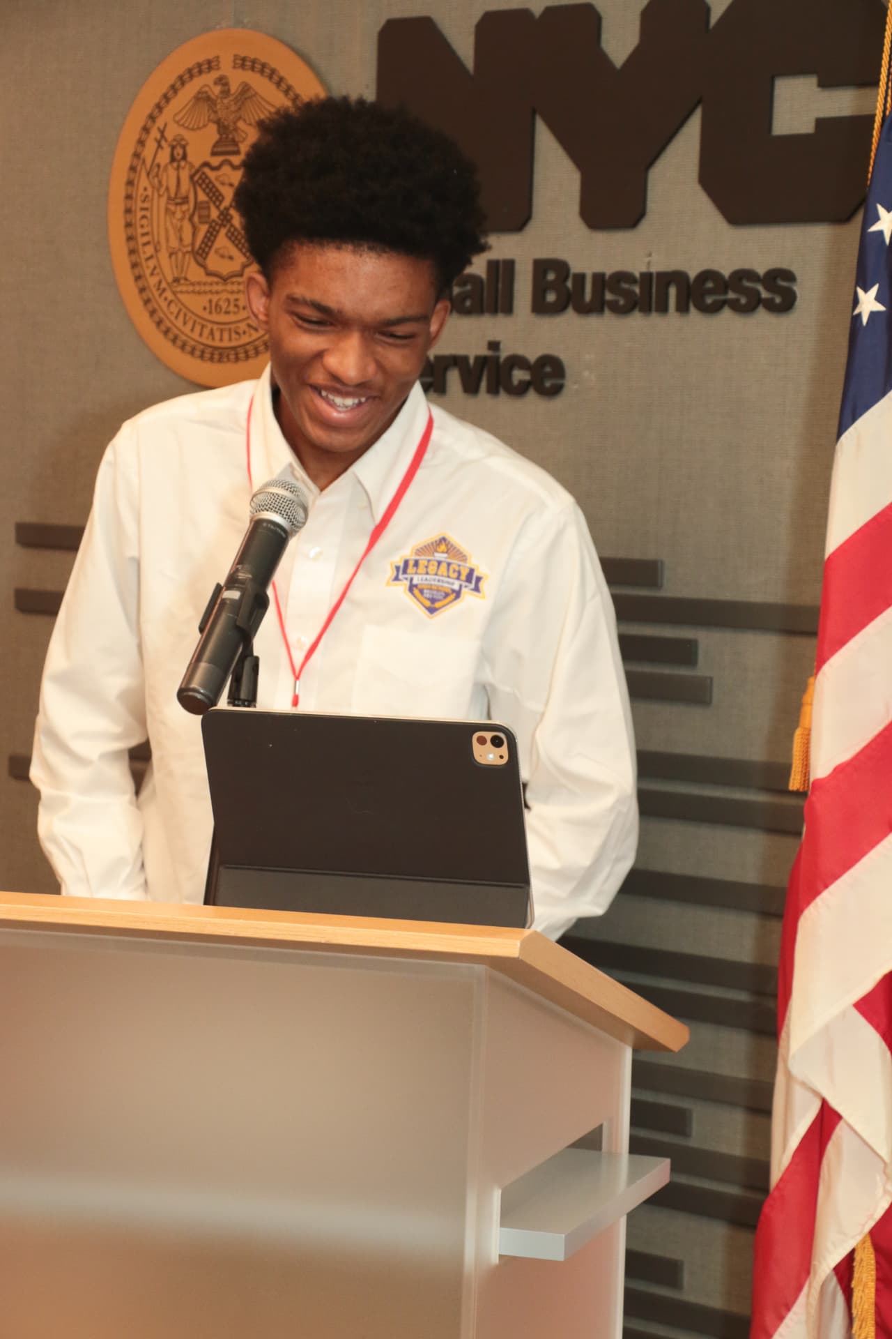 A student founder presenting his venture at the NYC Small Business Services podium